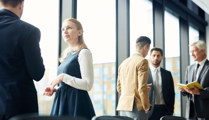 A woman standing near a window in a corporate office setting