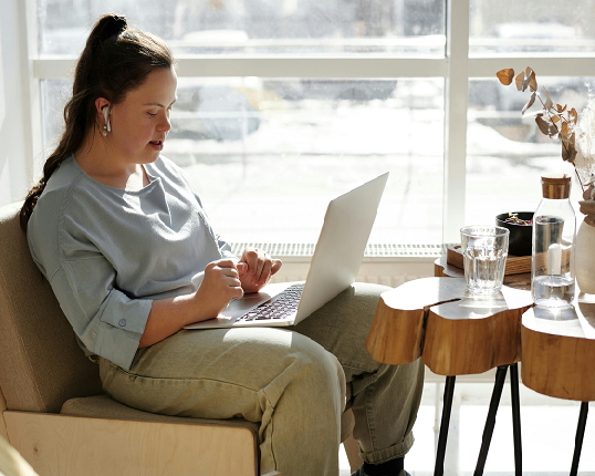 A person sits on the couch at their laptop