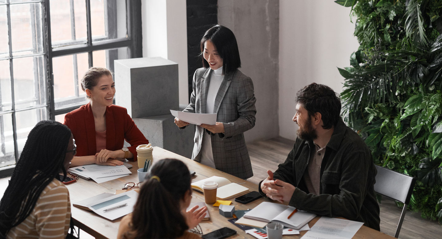 High angle portrait of diverse group of business people meeting at table in modern office interior decorated by plants