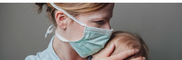 Mother in mask holding baby