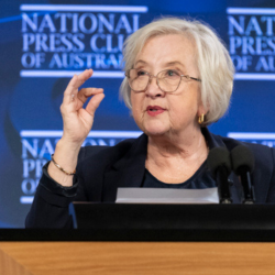 Woman standing behind microphone giving a speech