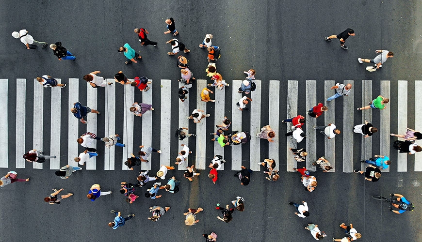 Street crossing scene from above, several dozen people crossing