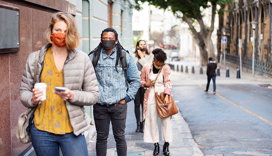 Multicultural city street scene, everyone is wearing a mask