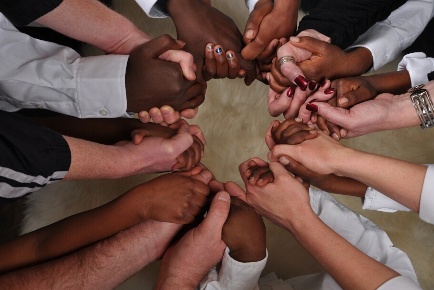 Many black and while hands linked together