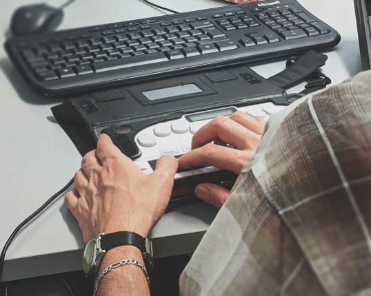 Someone using an adapted accessible computer keyboard