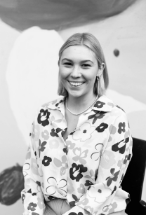 Black and white picture of woman with mid length hair wearing a floral jacket