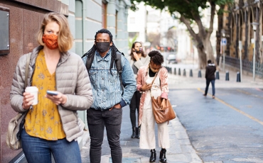 Multicultural city street scene, everyone is wearing a mask