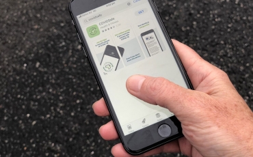 COVIDSafe App - hand holding iphone with the COVID-19 application