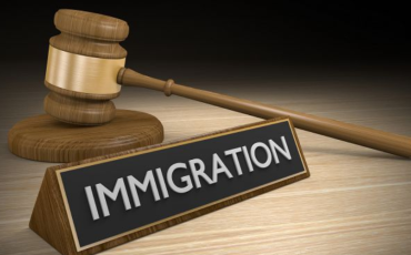 A court gavel sits behind a sign saying immigration