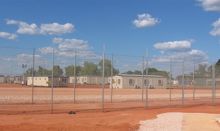 Immigration detention centre in dusty field