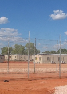 Immigration detention centre in dusty field