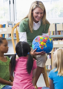 teacher showing globe to class