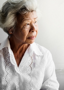 Elderly lady looking out a window