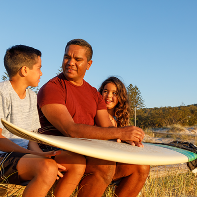 Aboriginal father talking to his children at the beach