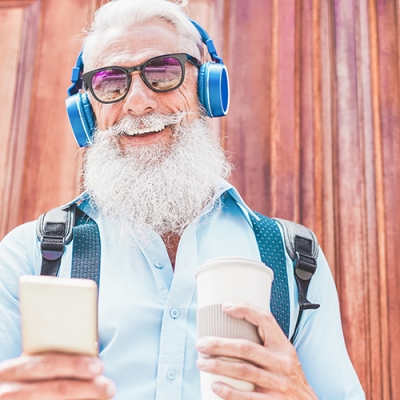 older man enjoying music and drinking coffee