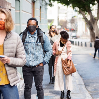 Multicultural city street scene, everyone is wearing a mask