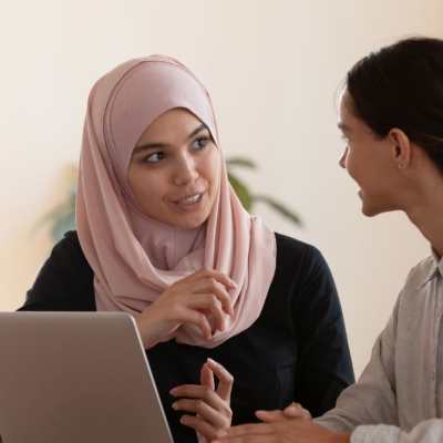 Multicultural businesswomen brainstorm cooperating at office meeting.